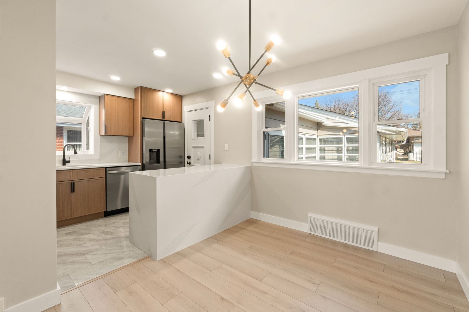 219 North Pine Street Mount Prospect, IL 60056 - Photo 6 of 20 a view of a kitchen with a sink dishwasher a kitchen island with wooden cabinets and floor to ceiling window