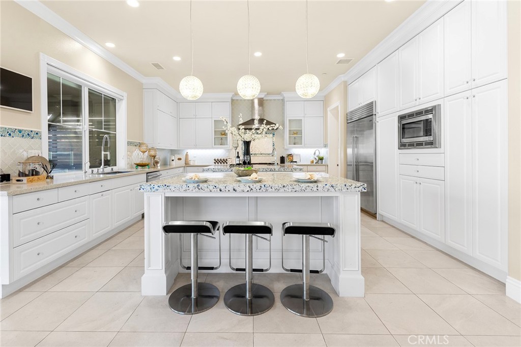 123 Calderon Irvine, CA 92618 - Photo 18 of 74 a large kitchen with kitchen island granite countertop lots of white cabinets appliances and furniture