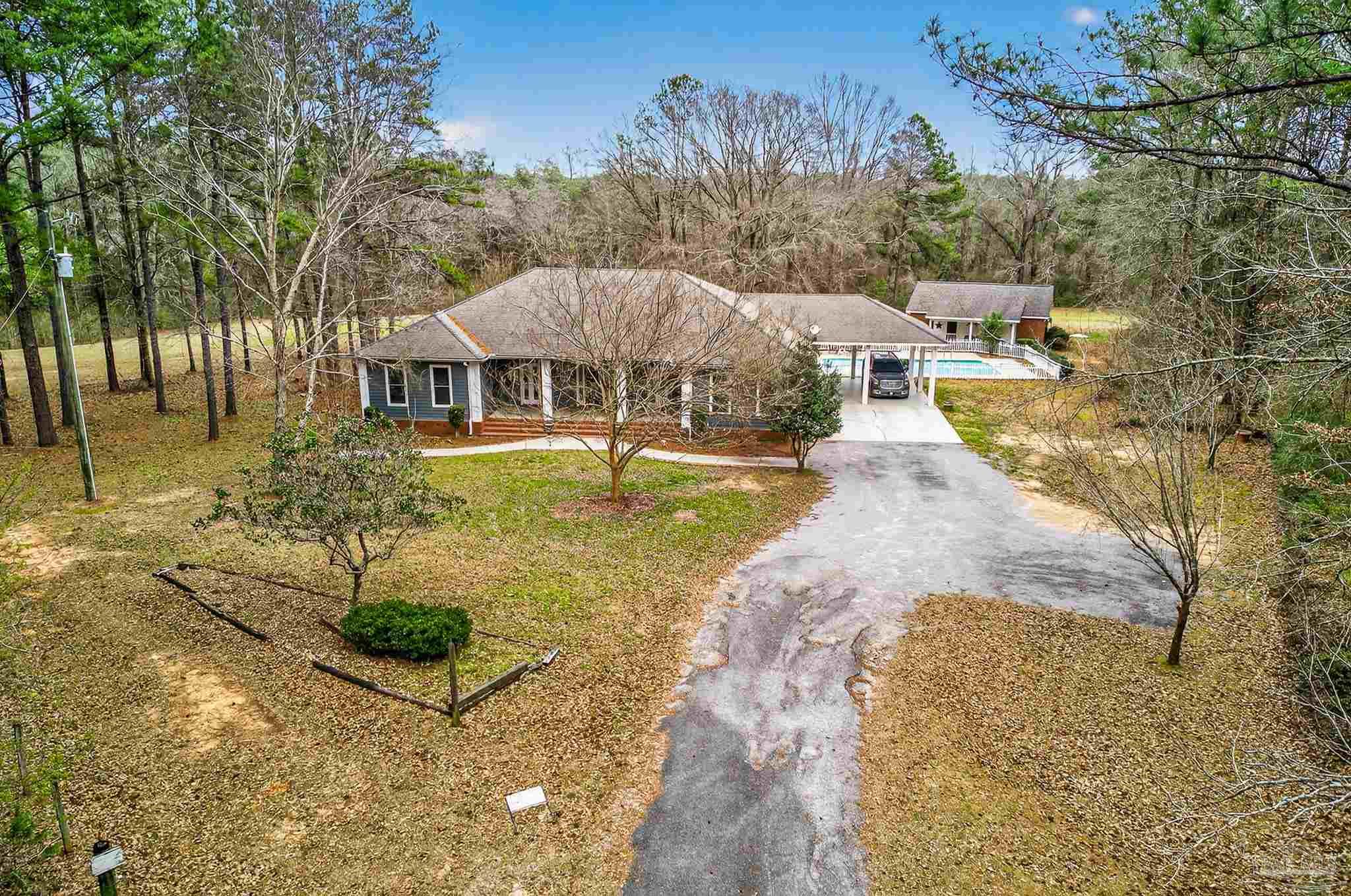 a view of a house with a yard and large tree