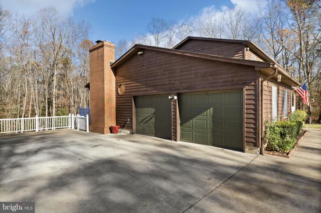 a view of a house with a big yard and large trees