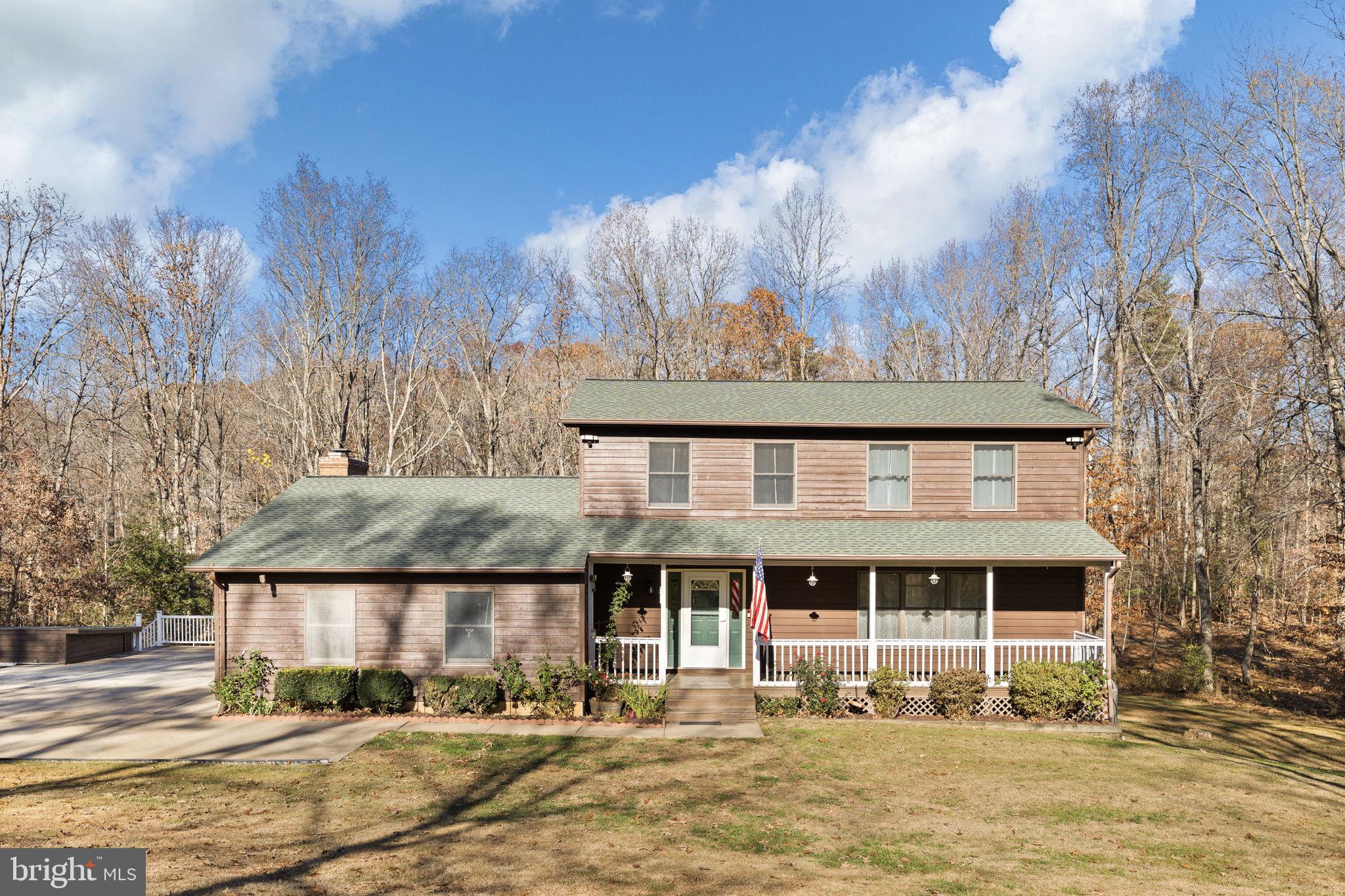4075 Red Gate Lane King George, VA 22485 - Photo 9 of 69 a front view of a house with a yard and trees in the background