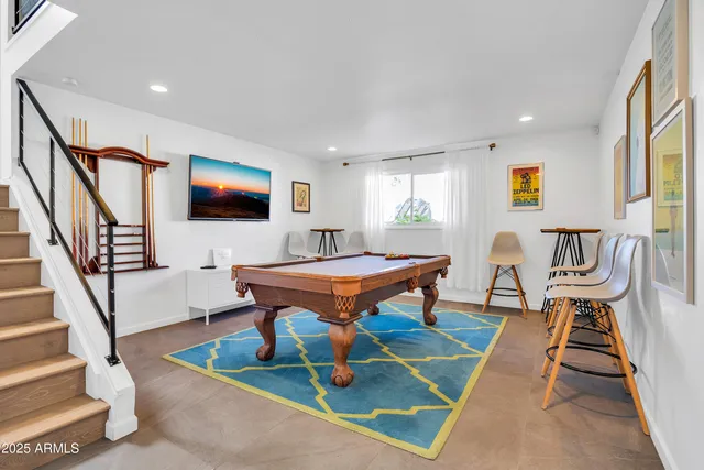 a living room with furniture pool table and a flat screen tv