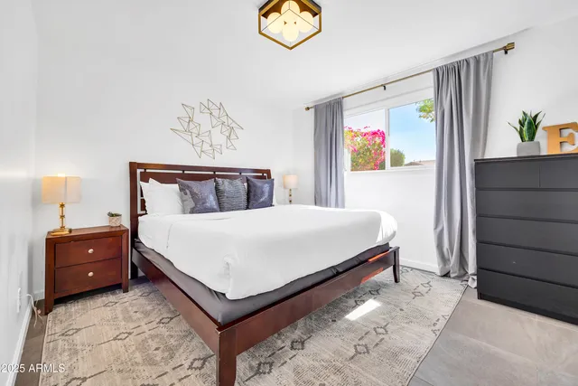 a spacious bedroom with a bed and a chandelier