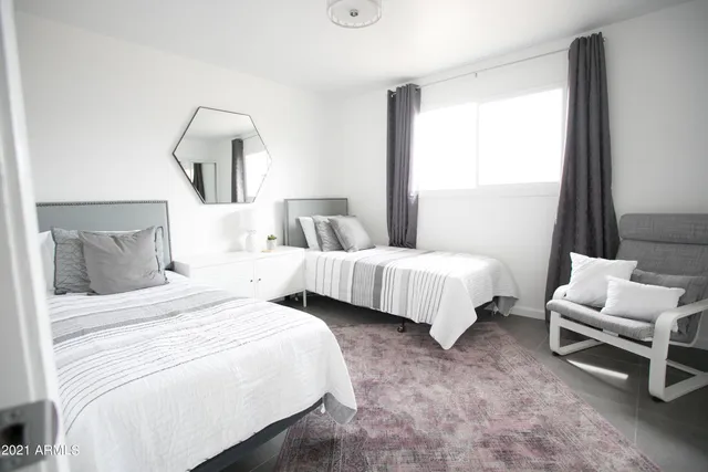 a bedroom with a bed and a large mirror