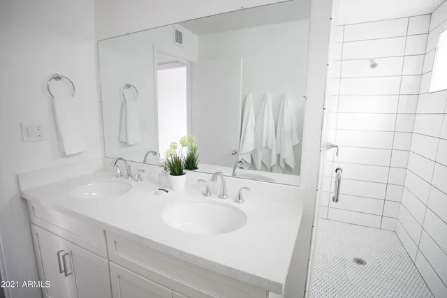 a bedroom with a bed and flat tv screen on the dresser