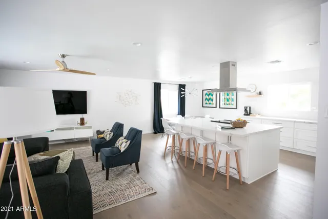 a kitchen with stainless steel appliances kitchen island granite countertop a table chairs and a refrigerator