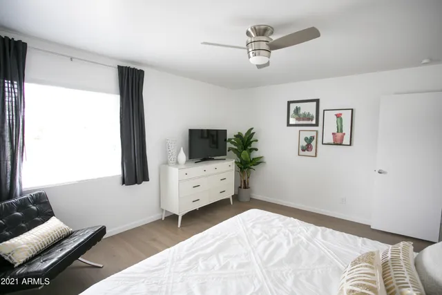 a bedroom with a bed and painting on the wall