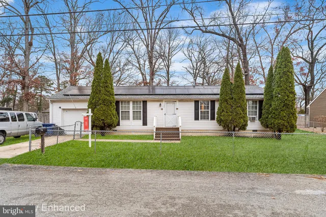 a front view of a house with a garden and trees