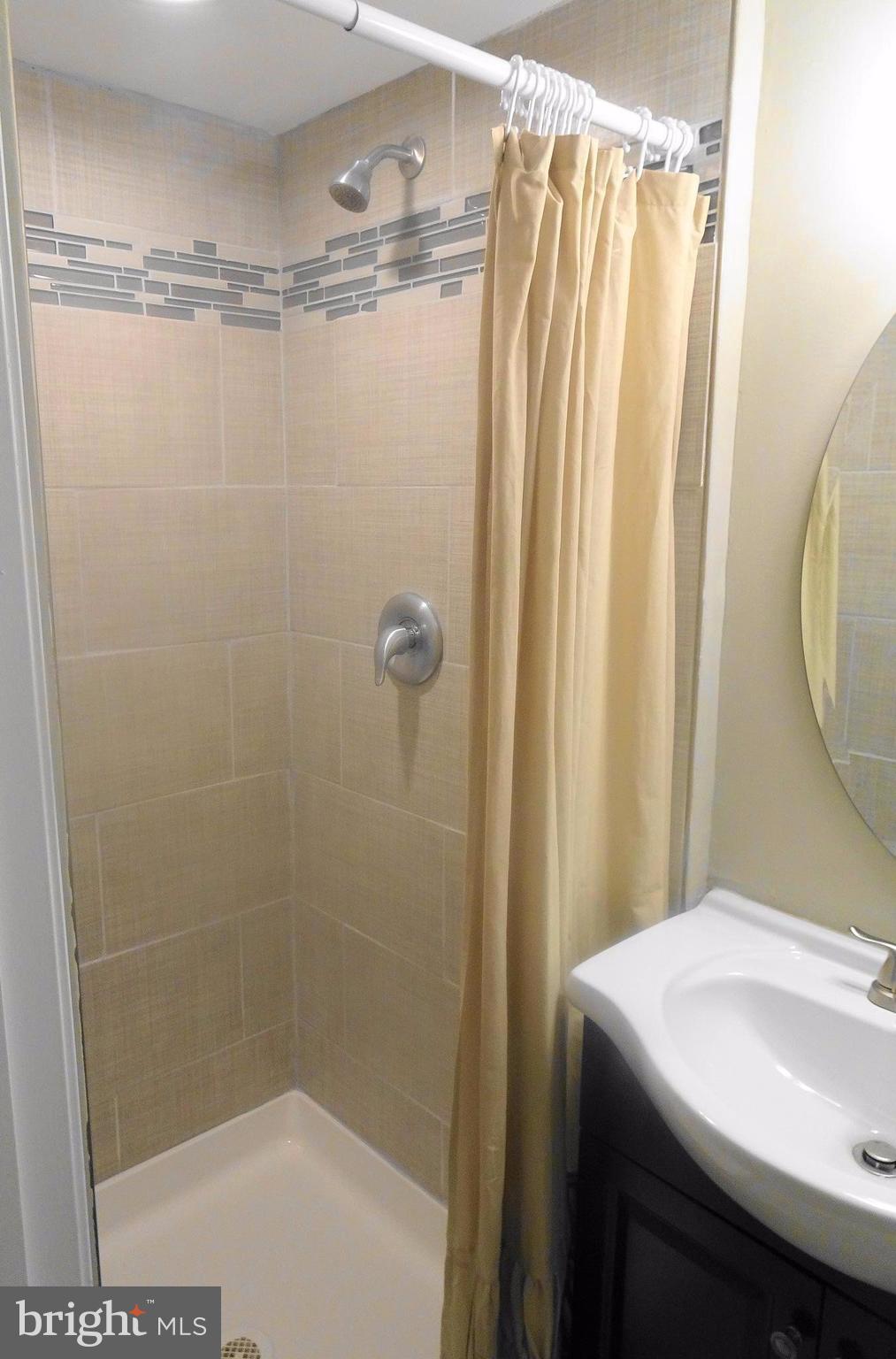 1406 Meridene Drive Baltimore, MD 21239 - Photo 22 of 30 a bathroom with a shower curtain and a sink