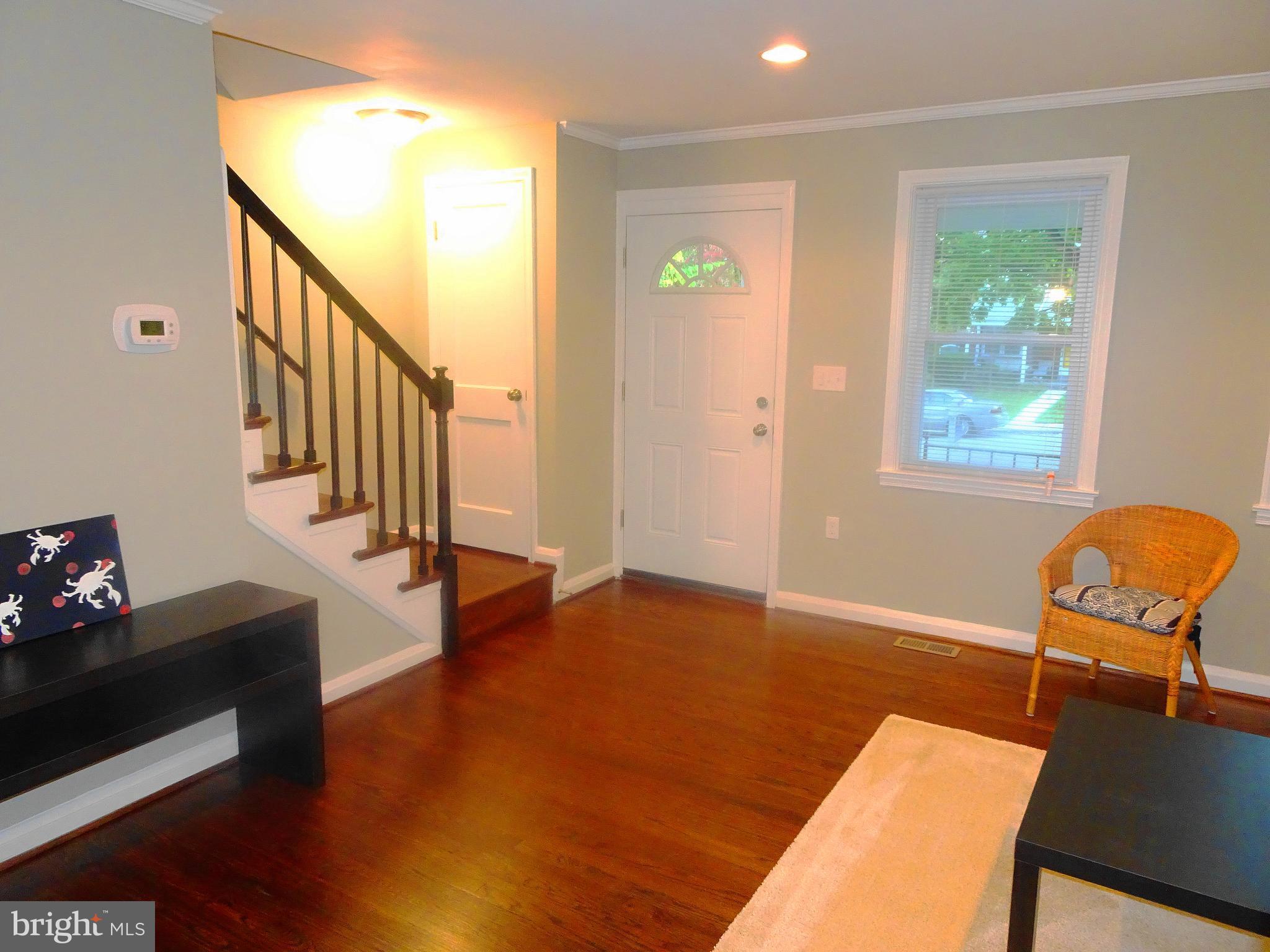 1406 Meridene Drive Baltimore, MD 21239 - Photo 8 of 30 a view of an empty room with wooden floor and windows