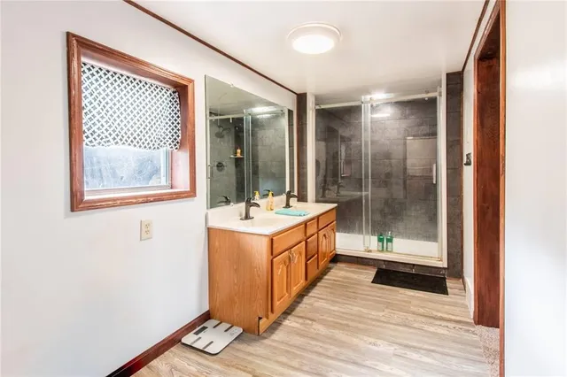 a bathroom with a double vanity sink toilet and shower