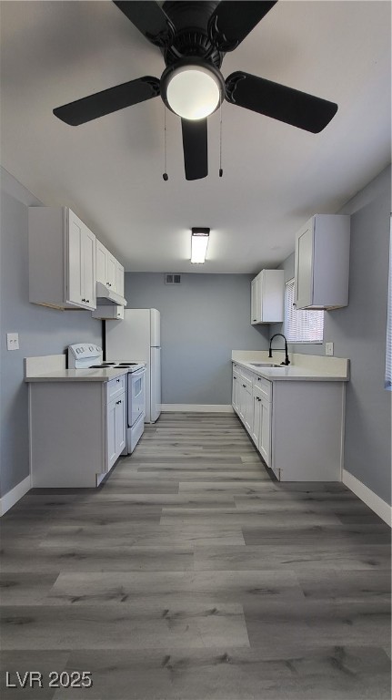 3240 Michael Way, Unit 3 Las Vegas, NV 89108 - Photo 13 of 22 Kitchen with light countertops, range, ceiling fan, and white cabinets