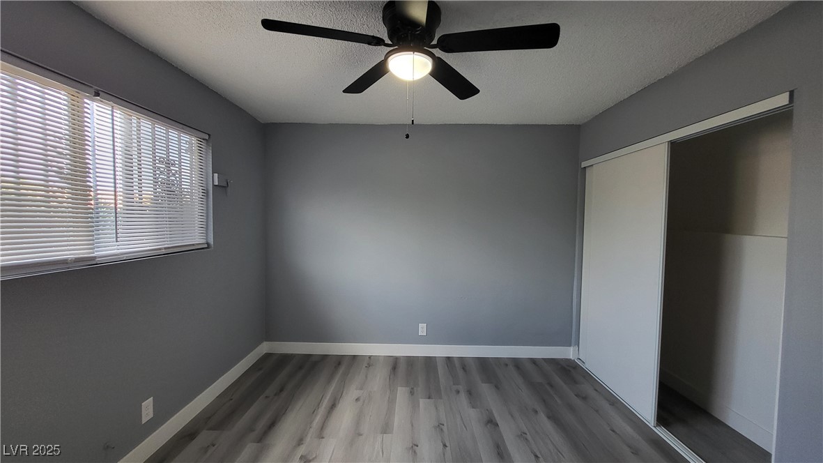 3240 Michael Way, Unit 3 Las Vegas, NV 89108 - Photo 18 of 22 Unfurnished bedroom with light wood-style floors, a textured ceiling, a ceiling fan, and a closet