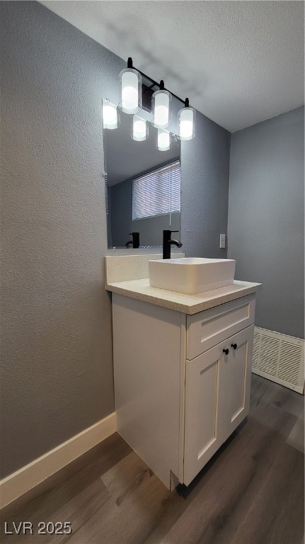 3240 Michael Way, Unit 3 Las Vegas, NV 89108 - Photo 21 of 22 Bathroom featuring a textured wall, dark wood-type flooring, vanity, and a textured ceiling