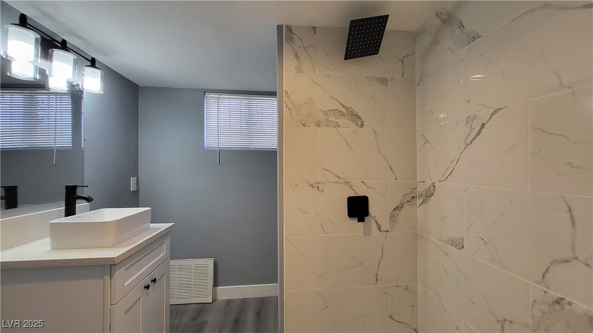 3240 Michael Way, Unit 3 Las Vegas, NV 89108 - Photo 22 of 22 Bathroom featuring a marble finish shower, vanity, and dark wood-type flooring
