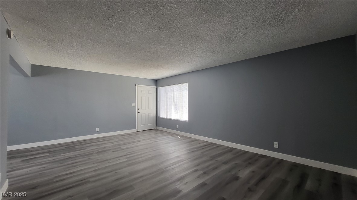 3240 Michael Way, Unit 3 Las Vegas, NV 89108 - Photo 3 of 22 Empty room with a textured ceiling and dark wood-type flooring