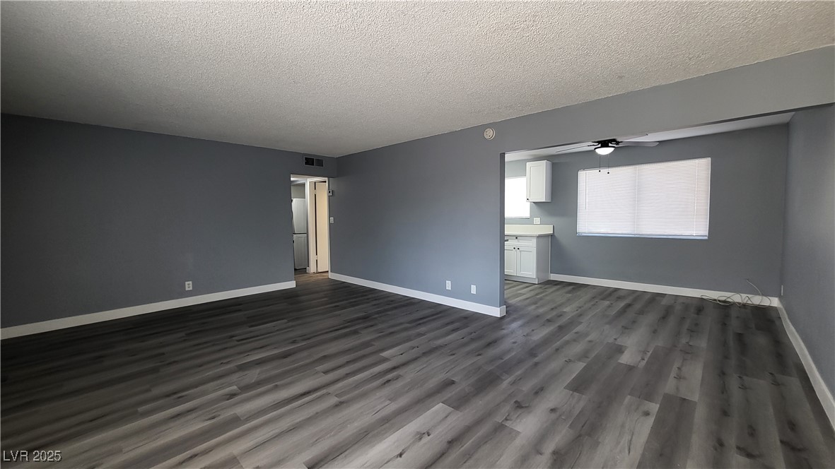 3240 Michael Way, Unit 3 Las Vegas, NV 89108 - Photo 5 of 22 Unfurnished living room with a textured ceiling, dark wood-style floors, and ceiling fan