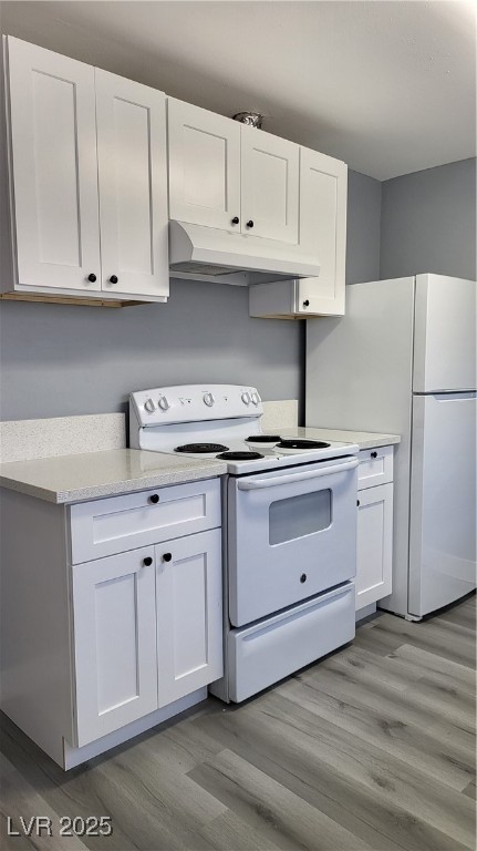 3240 Michael Way, Unit 3 Las Vegas, NV 89108 - Photo 10 of 22 Kitchen featuring white appliances, white cabinetry, range hood, and light wood-style floors