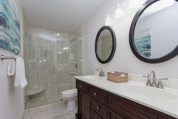 a bathroom with a double vanity sink mirror and toilet