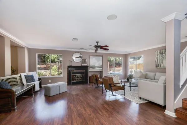 a living room with furniture flat screen tv and wooden floor