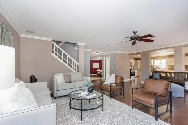 a living room with furniture or couches and a dining table with wooden floor