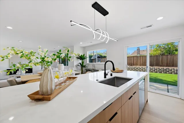 a kitchen with granite countertop a refrigerator and a stove top oven