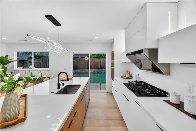 a living room with furniture kitchen view and a potted plant