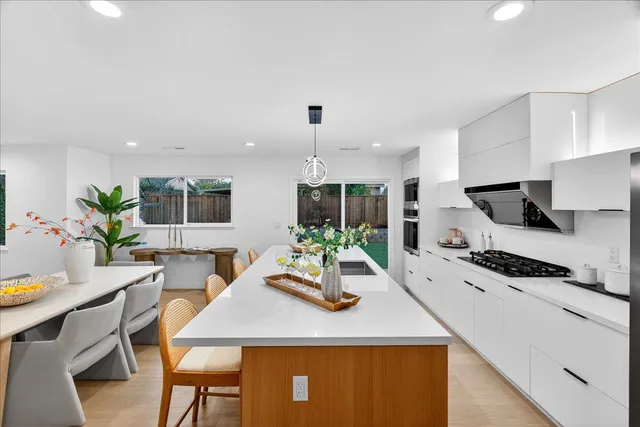 a patio with a table and chairs and potted plants