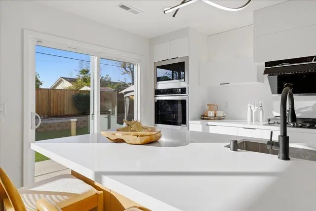 a kitchen with kitchen island a potted plant and a sink
