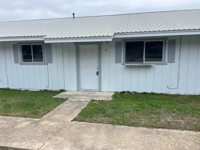an empty room with a chandelier fan and closet