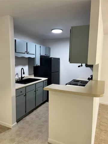 a kitchen with a refrigerator and ceiling fan