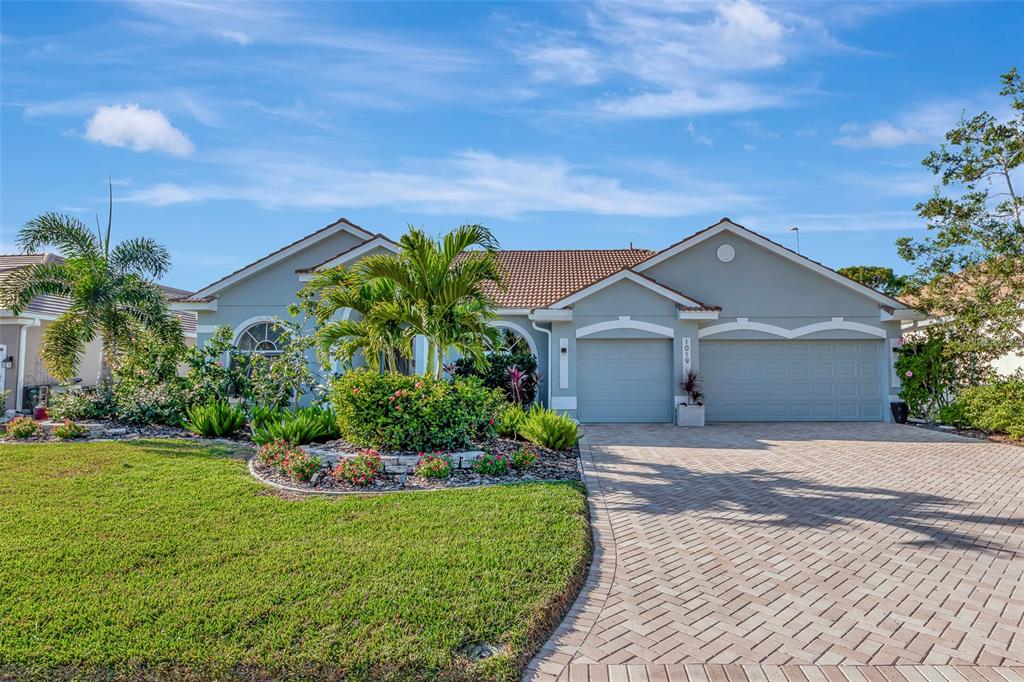 1019 Scherer Way Osprey, FL 34229 - Photo 1 of 56 a front view of a house with a yard and potted plants
