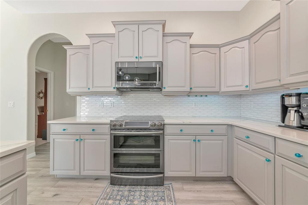 1019 Scherer Way Osprey, FL 34229 - Photo 3 of 56 a kitchen with white cabinets and appliances