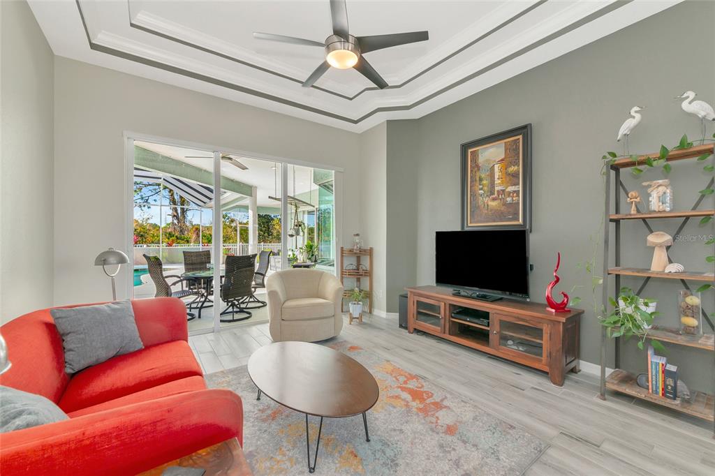 1019 Scherer Way Osprey, FL 34229 - Photo 9 of 56 a living room with furniture a flat screen tv and a floor to ceiling window