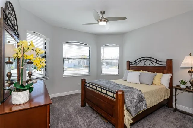 a bedroom with a bed and a dresser next to a window