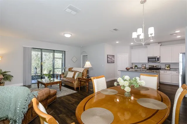 a living room with dining table furniture and a chandelier