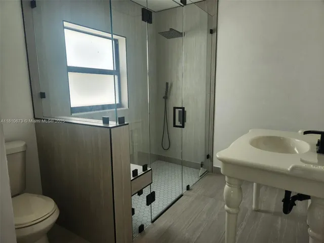 a bathroom with a sink toilet and shower