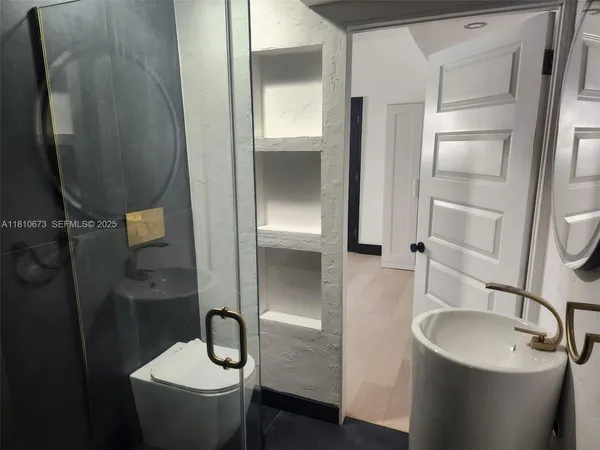 a bathroom with a granite countertop sink toilet and shower