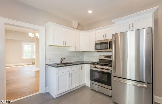a kitchen with white cabinets and stainless steel appliances