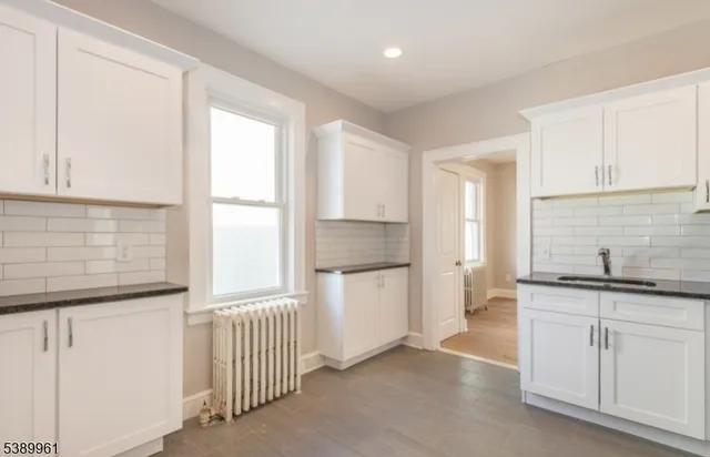 a kitchen with granite countertop white cabinets and white appliances