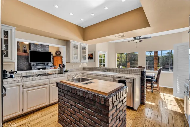 a kitchen with sink stove and chairs with wooden floor