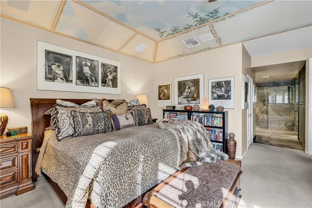 a bedroom with a large bed and a painting on the wall