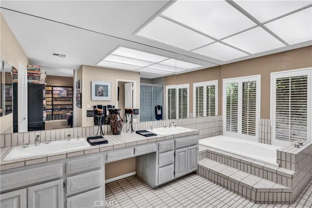 a bathroom with double vanity sink a mirror and a bathtub
