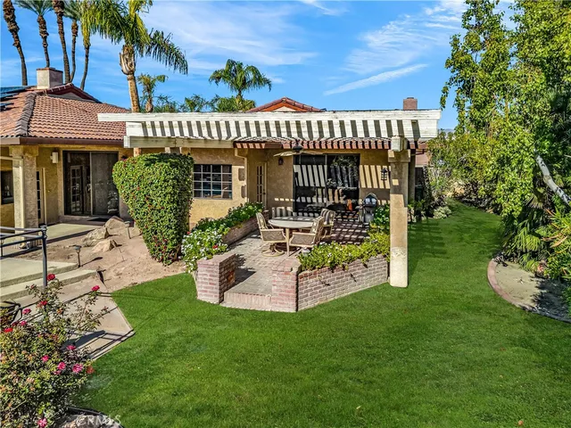 a view of a house with a yard and sitting area