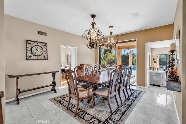 a dining room with furniture a chandelier and window