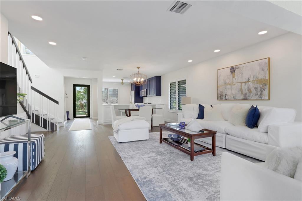 605 8th Avenue South, Unit 605 Naples, FL 34102 - Photo 12 of 50 Living room with a chandelier, wood-type flooring, recessed lighting, and stairs