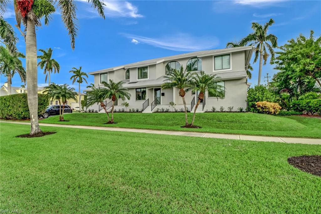 605 8th Avenue South, Unit 605 Naples, FL 34102 - Photo 2 of 50 View of front of property featuring stucco siding and a front yard