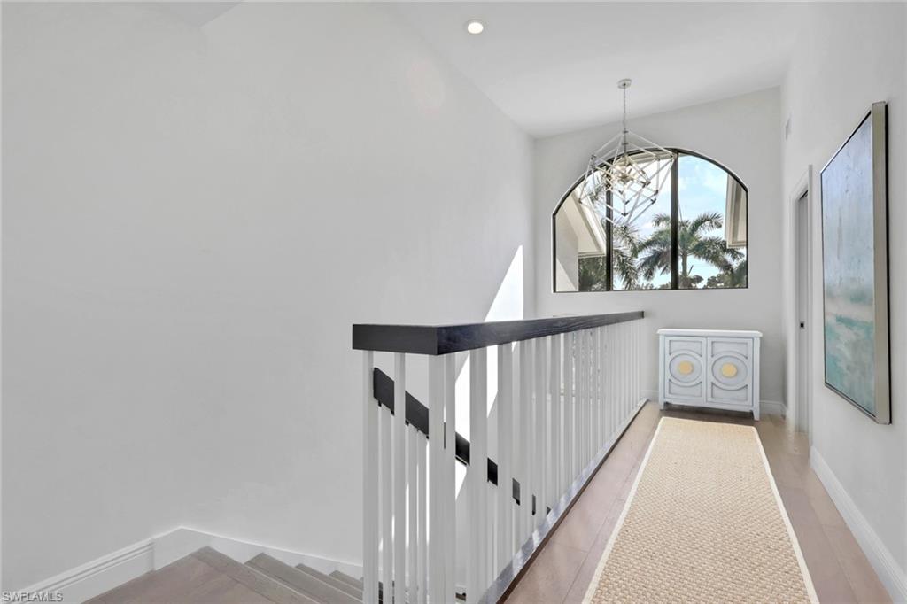 605 8th Avenue South, Unit 605 Naples, FL 34102 - Photo 22 of 50 Hall featuring an upstairs landing and a chandelier