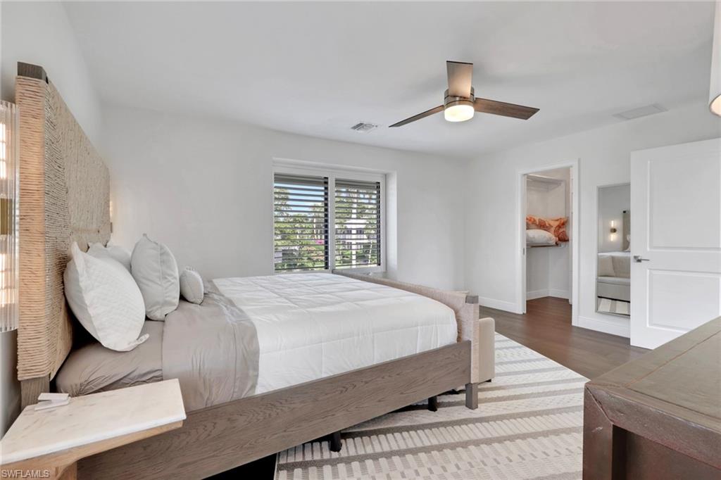 605 8th Avenue South, Unit 605 Naples, FL 34102 - Photo 26 of 50 Bedroom featuring a walk in closet, ceiling fan, and dark wood-style floors