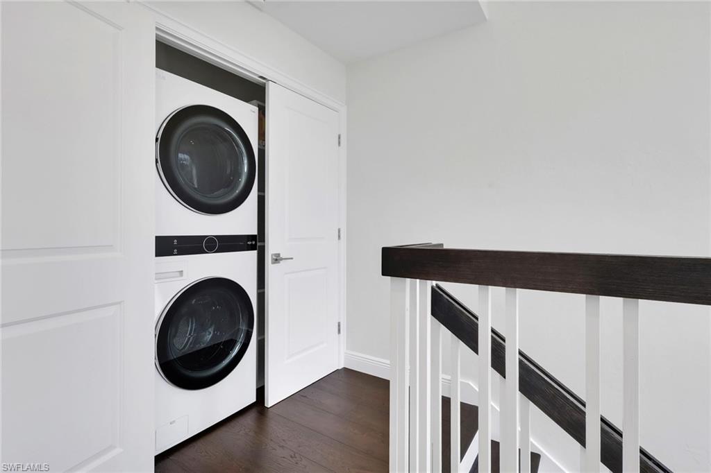 605 8th Avenue South, Unit 605 Naples, FL 34102 - Photo 30 of 50 Washroom with stacked washing machine and dryer and dark wood finished floors